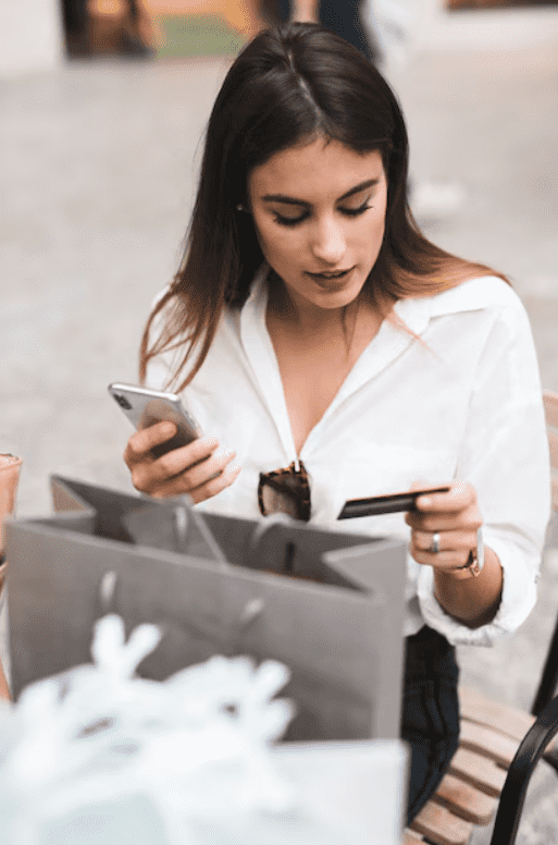 Mujer haciendo compra online desde su teléfono móvil con tarjeta