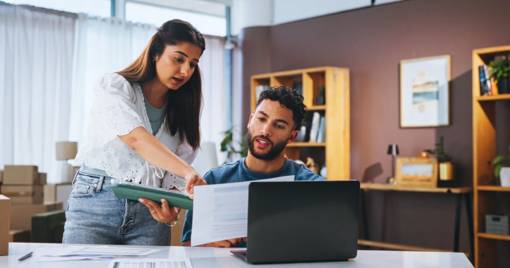 Dos personas revisan documentos de su empresa emergente para acogerse a la Ley de Startups