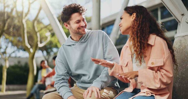 Jóvenes bilingües hablando sentados en un banco