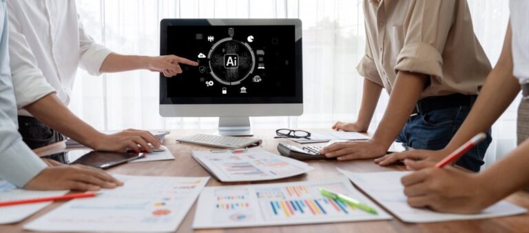 Personas aprendiendo en una mesa de trabajo sobre alfabetización en inteligencia artificial