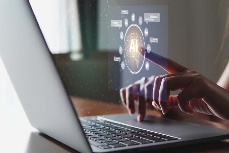 Mano encima de un portátil utilizando las aplicaciones de inteligencia artificial de este 2025