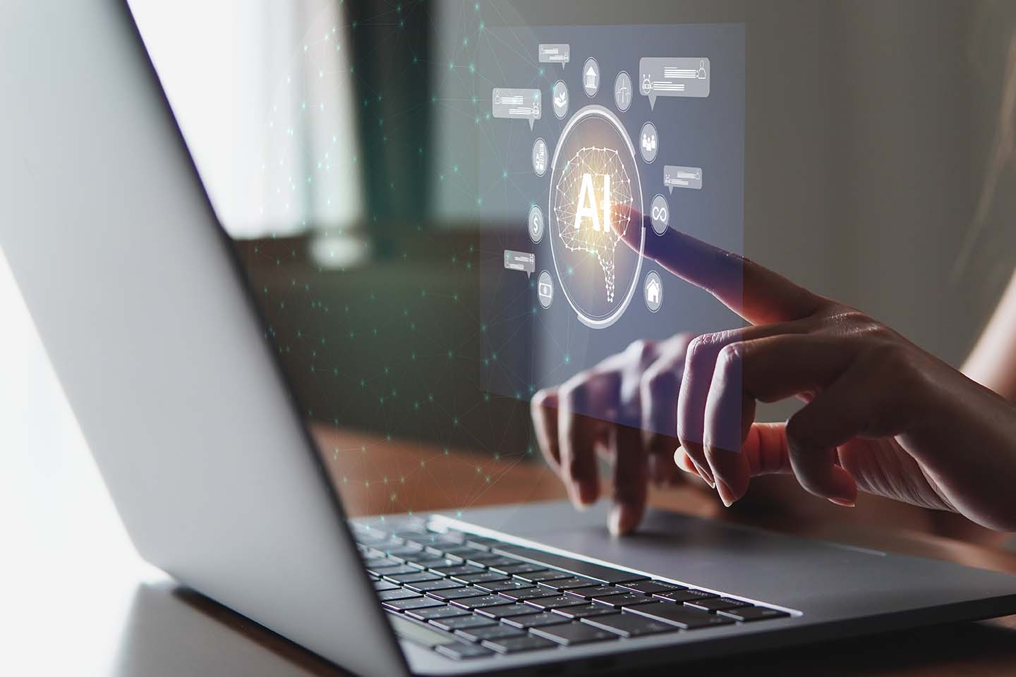 Mano encima de un portátil utilizando las aplicaciones de inteligencia artificial de este 2025