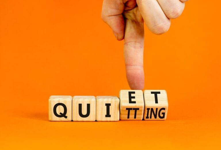 Dados de madera formando las palabras quiet y quitting, en referencia a la renuncia silenciosa en el trabajo